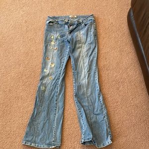 Size 9 low rise light wash stone jeans with butterfly design on right leg